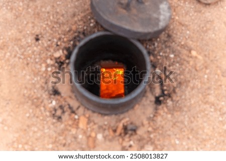 bricks making process. Man keeping giving coal in fire pit in brickfield