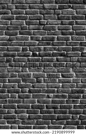 Bricks of an old building facade in Sauerland Germany. Uniform grid made by macons. Black and white greyscale background structure with horizontal fugues or interstices.