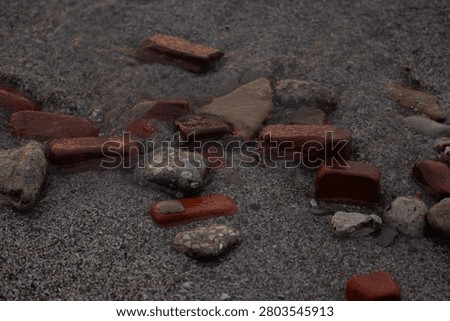 Bricks and Rocks in the Sand at the Beach