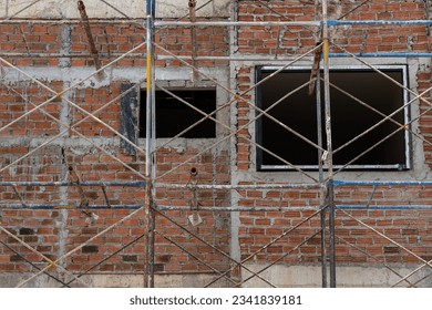 Bricks wall and cement background.Scaffolding and bricks wall on work site.Empty construction site.Red grunge brick wall texture.Empty construction site. - Powered by Shutterstock