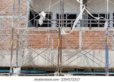 Bricks wall and cement background.Scaffolding and bricks wall on work site.Empty construction site.Red grunge brick wall texture.Empty construction site. - Powered by Shutterstock