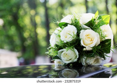 Bridal Bouquet Of White Roses On A White Car