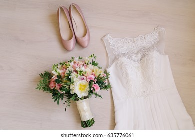 Bridal morning details. Beautiful bouquet of yellow and pink flowers, white wedding dress and leather shoes. Wedding composition, flat lay. - Shutterstock ID 635776061
