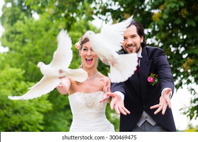 Bridal pair with flying white doves at wedding