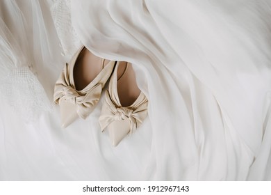 Bridal shoes closeup on a wedding dress background.