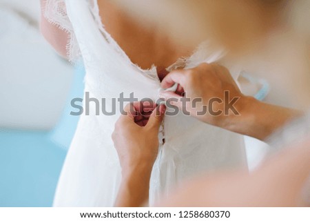 Bride back in dress with hands. Wedding getting ready.