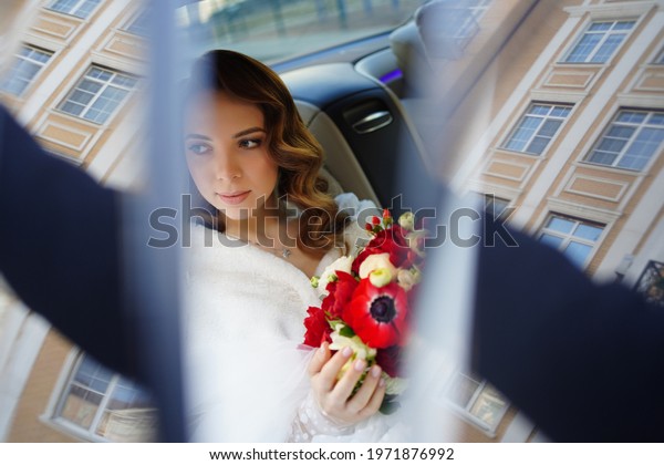 The bride in the back seat of the car. Renting\
a car for a wedding. organizing holidays. love and happiness of the\
newlyweds.