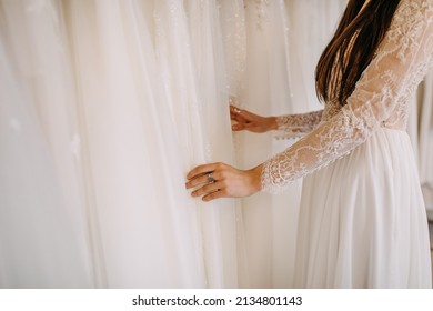 Bride To Be Choosing Wedding Dress In A Showroom. Closeup Of A Woman Client At A Wedding Gown Shop.