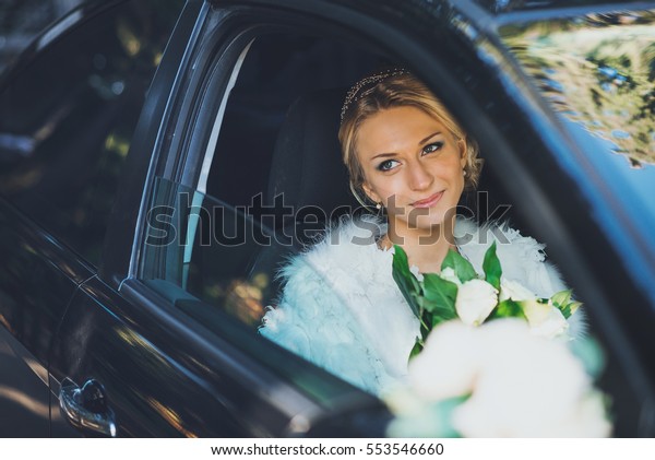 bride with a bouquet\
of roses in the car