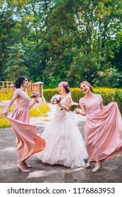 Bride And Bridesmaid In Nature With Bouquets Of Flowers. Funny Wedding Moments, Bride Show Bridesmaids Her New Ring. Girls In Shock.