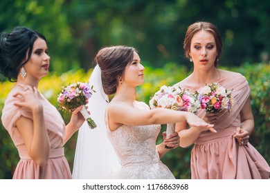 Bride And Bridesmaid In Nature With Bouquets Of Flowers. Funny Wedding Moments, Bride Show Bridesmaids Her New Ring. Girls In Shock.