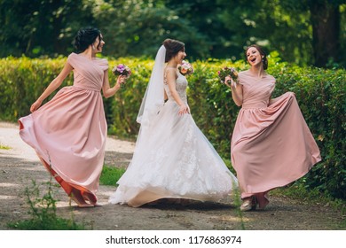 Bride And Bridesmaid In Nature With Bouquets Of Flowers. Funny Wedding Moments, Bride Show Bridesmaids Her New Ring. Girls In Shock.