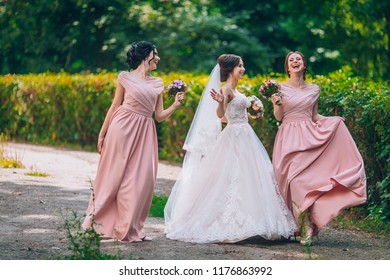 Bride And Bridesmaid In Nature With Bouquets Of Flowers. Funny Wedding Moments, Bride Show Bridesmaids Her New Ring. Girls In Shock.