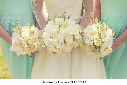 Bride with bridesmaids holding wedding bouquets - Powered by Shutterstock