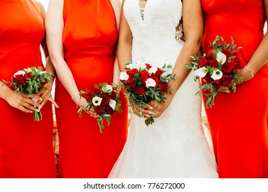 Bride And Bridesmaids In Red Dresses Holding Bouquets