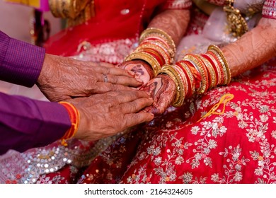 Bride dad is putting haldi on the hands on bride at the time of Indian wedding 