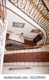 A Bride Descends A Staircase To See Her Groom