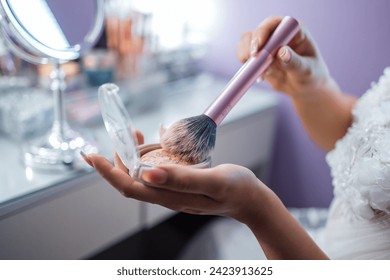 bride doing makeup before her wedding in room. Detail of hands