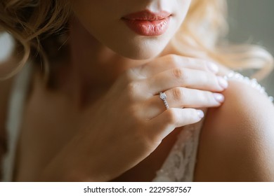 the bride gently touches her dear engagement ring