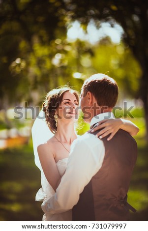 The bride and groom in the background of the park