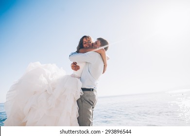 Bride And Groom By The Sea On Their Wedding Day