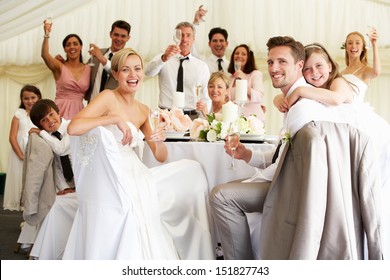 Braut und Bräutigam feiern mit Gast an der Rezeption