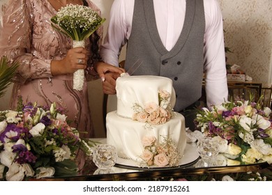 Bride And Groom Cutting The Cake With A Knife At The Engagement Party.