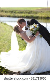 A Bride And Groom Dance And Dip In A Long Kiss