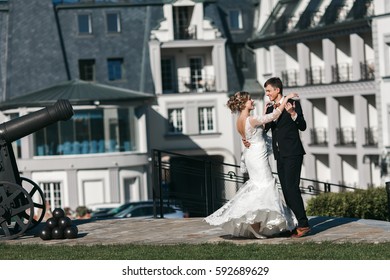 Bride And Groom Dance Together On The Building Background