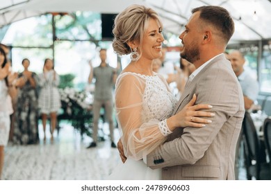 Bride and groom dancing the first wedding dance against the background of guests in an evening restaurant - Powered by Shutterstock