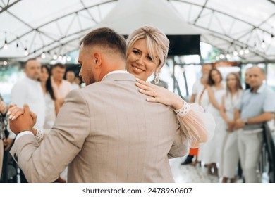 Bride and groom dancing the first wedding dance against the background of guests in an evening restaurant - Powered by Shutterstock