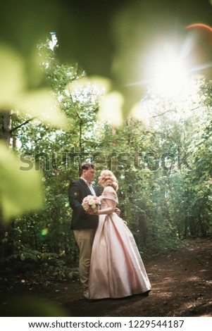 bride and groom dancing in the forest background and sunlight.
