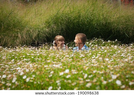 Bride and groom in a field of daisies