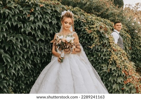 bride and groom in the garden among greenery. Royal wedding concept. Chic bride's dress with a long train. Tenderness and calmness. Portrait photography