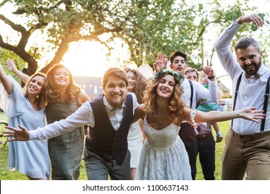 Bride, Groom, Guests Posing For The Photo At Wedding Reception Outside In The Backyard.