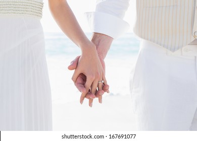 Bride and groom hand in hand at the beach