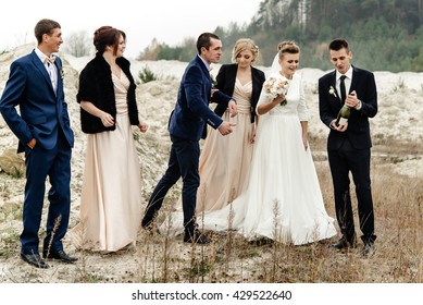 Bride And Groom With Happy Groomsmen And Bridesmaids Having Fun And Laughing And Popping Champagne, Luxury Wedding Celebration