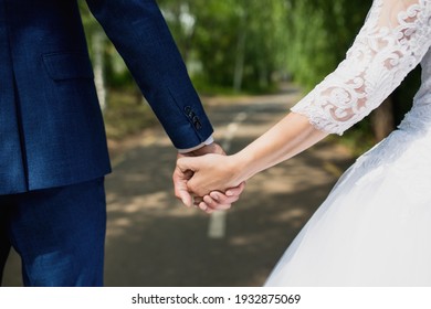 the bride and groom hold hands