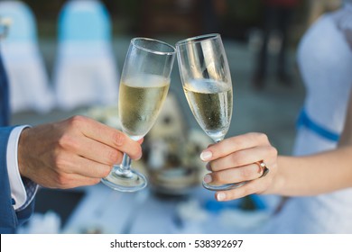 bride and groom holding beautifully decorated wedding glasses with champaign - Powered by Shutterstock