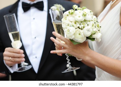 Bride and groom are holding champagne glasses
