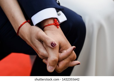 bride   groom holding hands and matching bracelets  History the red thread