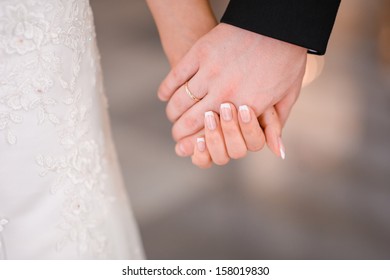Bride And Groom Holding Hands Outdoors