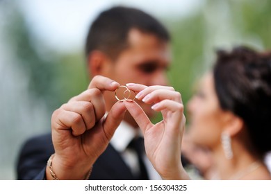Bride And Groom Holding Hands In A Ring