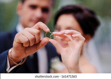 bride and groom holding hands in a ring