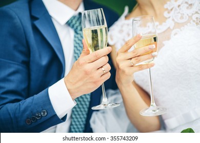 Bride and groom holding wedding champagne glasses - Powered by Shutterstock