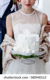 Bride And Groom Holding Winter Wedding Cake 