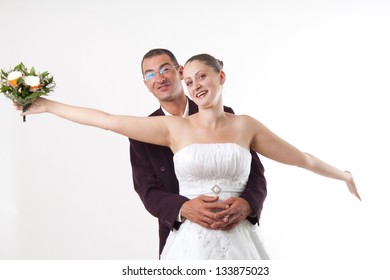 Bride An Groom Hug. Studio Shot Against Light Background