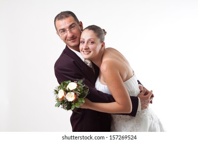 Bride An Groom Hug. Studio Shot Against Light Background