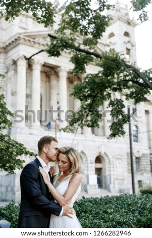 Bride and groom hugging in the old town street. Wedding couple in love. Luxury rhinestone dress. Hot summer days.