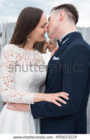 the bride and groom kiss in the locker room of the bamboo on the beach